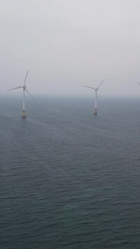 Jeju Island, Jeju-Do, South Korea,  Sinchang Windmill Coastal Road landscape, line of wind mills power generators along the coast, offshore wind farm energy turbines, aerial drone view, green energy