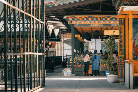 View of a vibrant market scene unfolding with colorful textiles, fresh produce, and the lively buzz of commerce in Centenary Farmers Market, Thimphu, Bhutan.