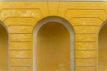 Yellow Ochre Architectural Wall with Arched Niches and Rusticated Texture Classic Neoclassical Facade Detail Background