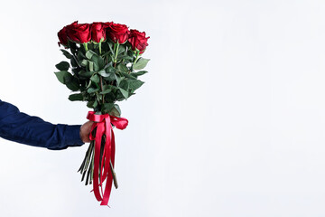 Valentine's day celebration. Man with beautiful bouquet of red roses on white background, closeup. Space for text