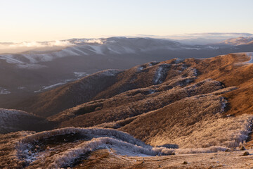 Malowniczy zachód słońca w zimowych Bieszczadach, góry pokryte śniegiem o złotej godzinie. © W Podróży do Chmur