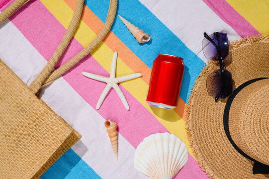 A red can of cold drink on the beach. View from above. Summer seaside vacation.