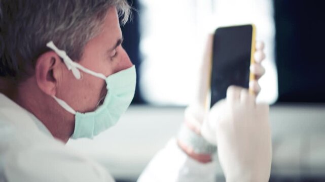 Doctor cleaning smartphone wearing gloves in coronavirus times