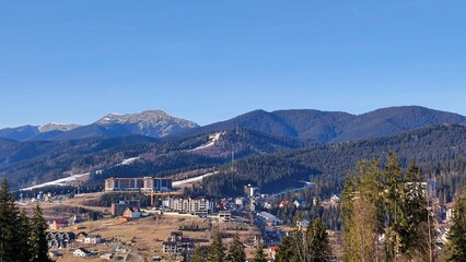 Panoramic mountain town in a forested valley under clear blue sky © Anet Kole