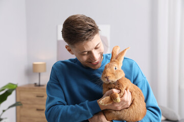 Happy man with cute bunny at home