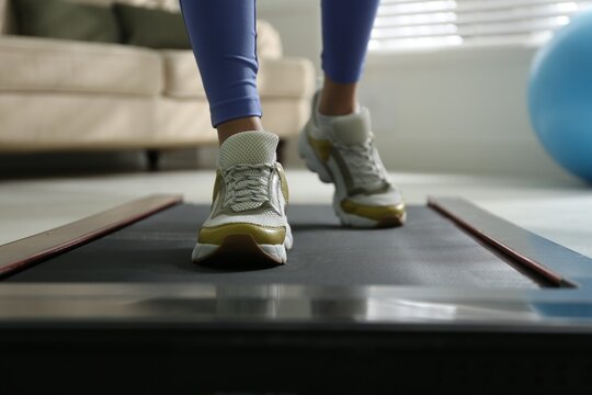 Woman training on walking treadmill at home, closeup