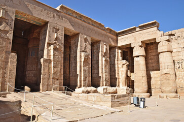 Obraz premium The Mortuary Temple of Hatshepsut in Deir el-Bahari, Egypt, with statues lining the grand colonnade.