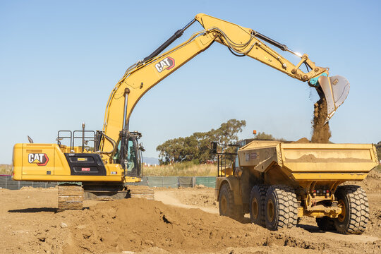 Construction site with a CAT excavator in operation, performing earthmoving work on an active building project. Heavy machinery at work, industrial equipment used for digging, January 29 , 2026