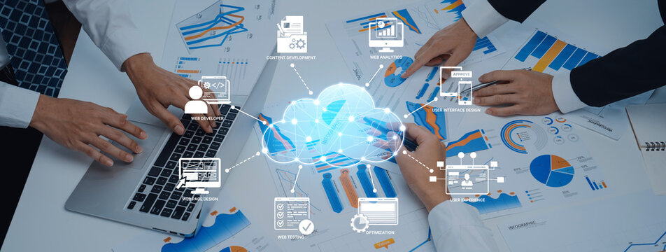 Business professionals engage in collaboration over data analysis with charts and laptop in a modern workspace, illustrating the impact of cloud technology in teamwork. Trope