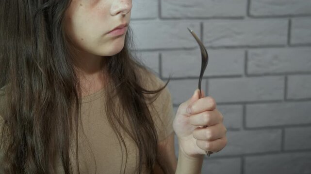 Teenager with an empty fork. Portrait of a teenage girl with a hungry look looking at an empty fork