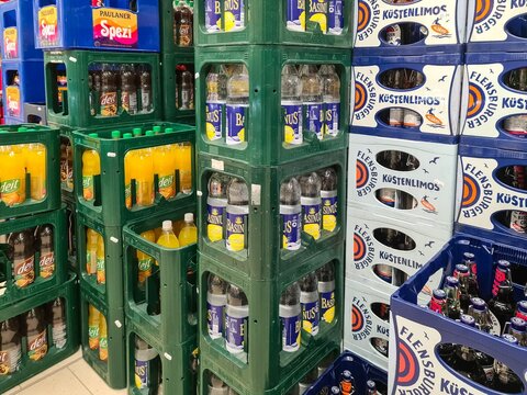 Kiel, Germany - 28. January 2026: Stacking beverage crates in a German supermarket aisle
