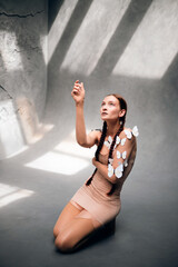 Model poses with butterflies on skin while raising hand in a studio setting during daylight hours © Тамара Печеная