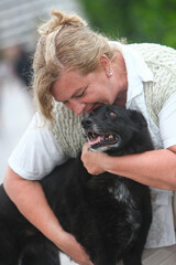 Obraz premium Portrait of a mature woman and her dog sharing a loving moment outdoors, showing mutual affection and companionship.