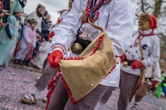 Costumed participants in festive attire and masks celebrate the Fasnacht, give out candy at the carnival parade in the historic town, Zug, Switzerland