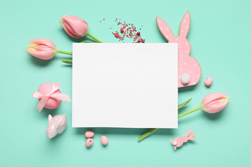 Naklejka premium Composition with blank card, Easter eggs, decorative bunnies and tulip flowers on turquoise background