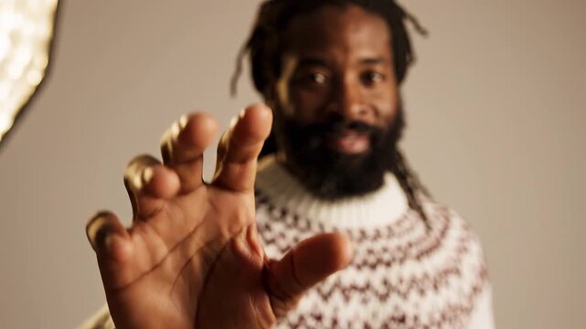 Man in patterned sweater pointing finger