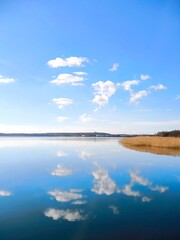Fototapeta premium A perfect mirror reflection of clouds in the calm water of a lake