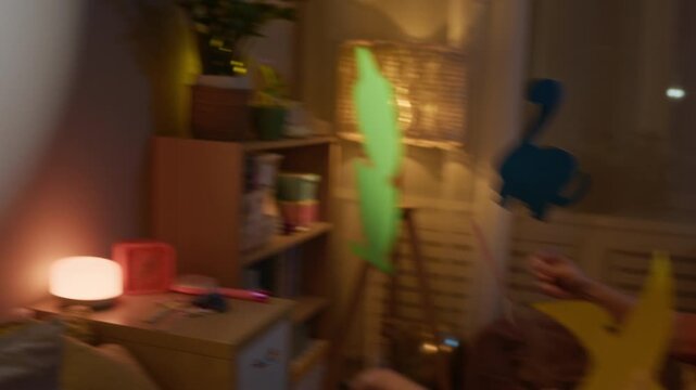 Family of three communicating, sharing emotions while playing shadow puppets at home