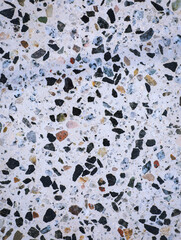 Terrazzo flooring texture with a polished concrete surface, featuring dark marble chips and stone fragments. Seamless pattern suitable for creative backgrounds, graphic and web projects.