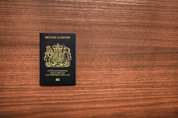British Passport on the left hand side on Wooden Surface