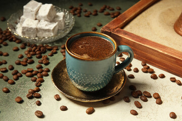 Fototapeta premium Cup of hot coffee and plate with turkish delight on grunge background, closeup