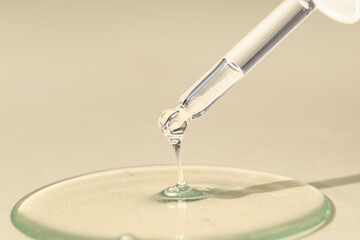 Pipette with cosmetic oil on beige background, closeup