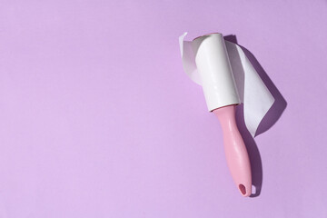 Fototapeta premium Sticky lint roller on lilac background
