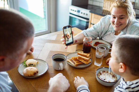 Family video call with grandmother during breakfast at home