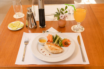 Grilled fish dish with vegetables and juice served at a restaurant table.