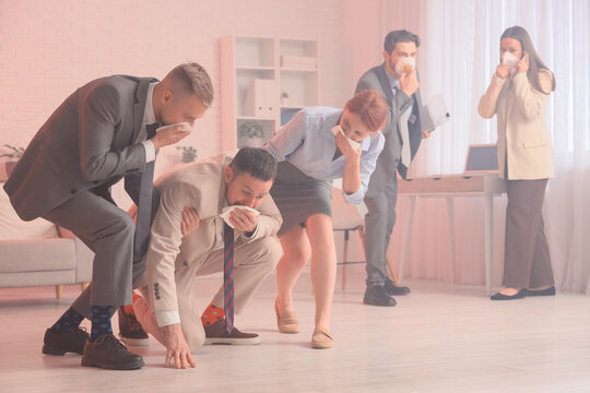 Business people covering faces with wet tissues in burning office building