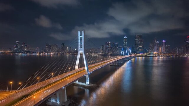 Nighttime drone hyperlapse flying forward above Atal Setu, Mumbai, illuminated bridge struct