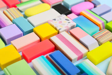 Colorful rubber erasers on blue background, closeup