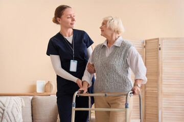 Fototapeta premium Nurse and senior woman with walker at home