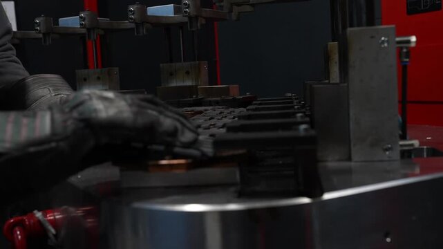 Manual placement of metal washers into a fixture during manufacturing setup, showing accurate positioning, repeatable handling and careful preparation for a precise industrial production process.