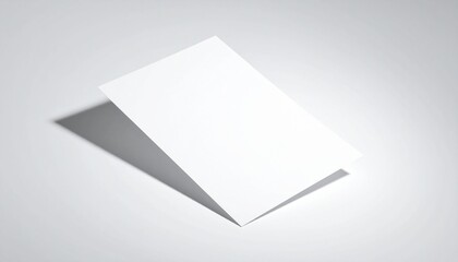 A white sheet of paper is tilted on a plain surface, viewed from above, casting a subtle shadow.