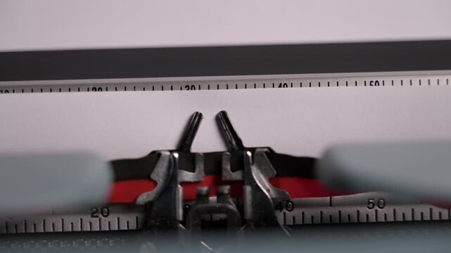 Close-up of vintage typewriter mechanism printing the words END on paper. Moving metal parts and classic design create a nostalgic retro writing atmosphere.