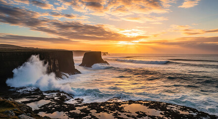 Obraz premium Dramatic sunset over ocean waves crashing against rugged cliffs.