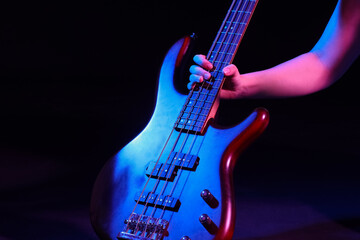 Male hand with modern electric guitar on dark background