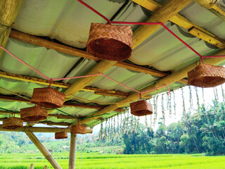 Handcrafted Woven Bamboo Decorations Hanging Under Thatch Roof