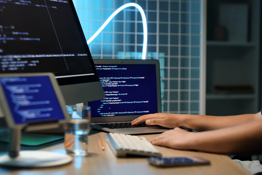 Male programmer working with modern laptop at table in office, closeup