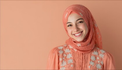 Young woman wearing a traditional headscarf smiles brightly against a solid background