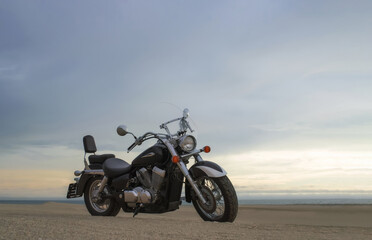Fototapeta premium A motorcycle stands still beneath a vibrant sunset sky, capturing a powerful sense of freedom, adventure, and independence, symbolizing the thrill of open roads, and personal journeys
