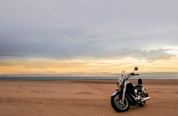 A motorcycle rests beneath a vibrant sunset sky, evoking freedom, adventure, and independence, symbolizing open roads, personal journeys, and the endless desire to explore new horizons.