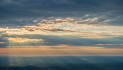 Sky with sunbeams breaking through clouds at sunset, a beautiful atmospheric natural phenomenon