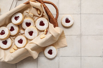Naklejka premium Wicker basket with sweet cookies on white tile background. Valentine's Day celebration
