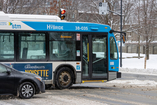 Canada, Montreal, 25 December 2025 : Snowy winter day city hybrid bus waits at red light