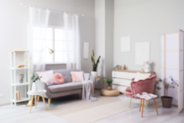 Fototapeta premium Cozy sofa with pillows, plaid and armchair with cushion in living room