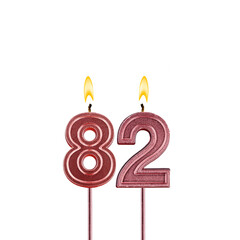 Lit birthday candle - Candle number 82 on white background
