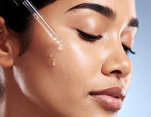 Young woman applying serum to her face for skincare routine.