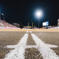 Obraz premium American football stadium field at night with goal posts and bright floodlights, illuminated sports arena during game preparation for broadcasting and advertising use
